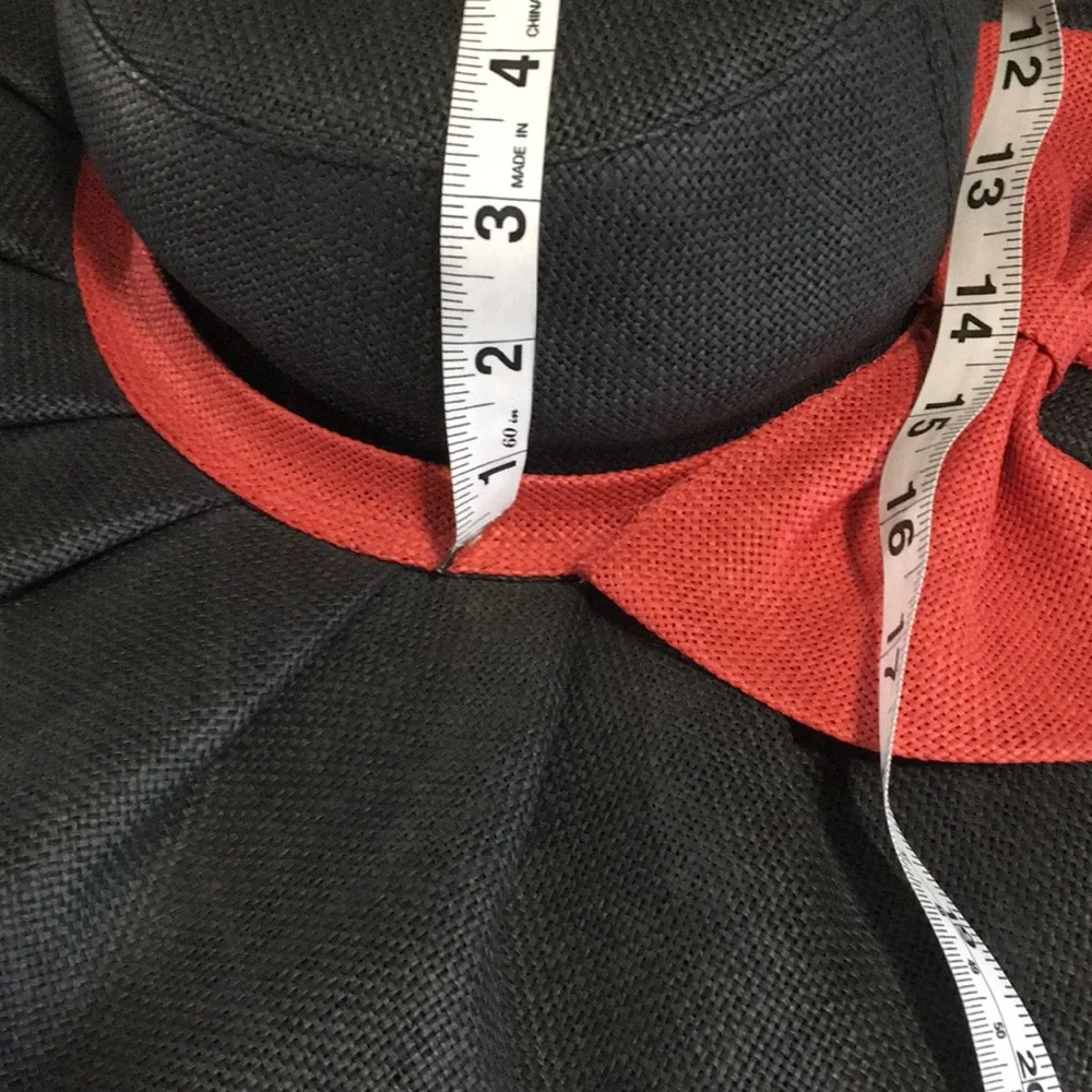 Woman’s black wide brim floppy burlap type hat with red bow.